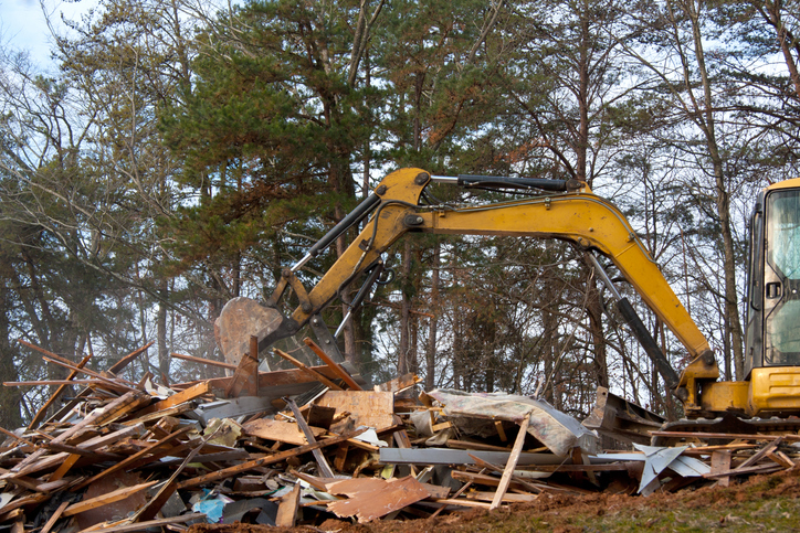 Excavator demolition activity on an old building.